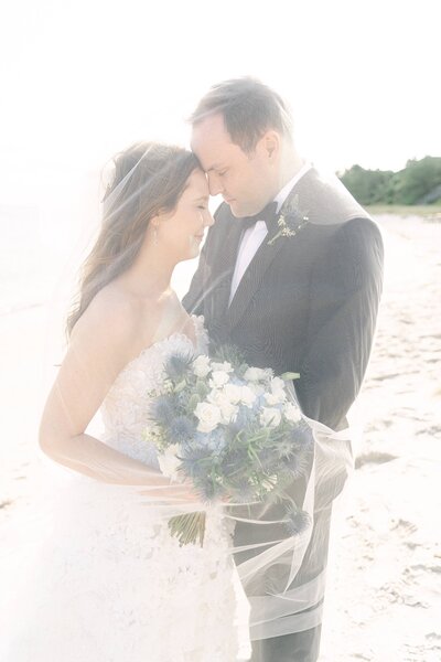 Bride & Groom embracing under a veil on the beach of Hyannis Port in Cape Cod