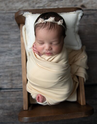 baby girl wrapped in yellow with flower headband