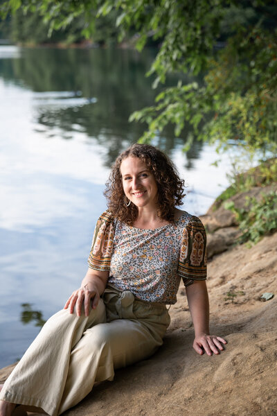 A woman sits by lake for personal branding sessions in Baltimore, Maryland