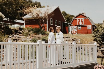 Couple standing together on bridge at wedding venue, Berkshire Farm Wedding