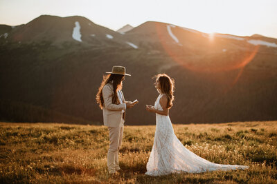 Wedding couple reading vows outside in front of mountains