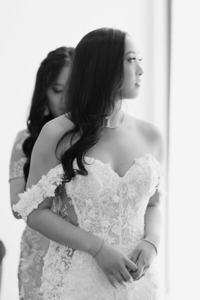 bride and groom sitting in front of large window