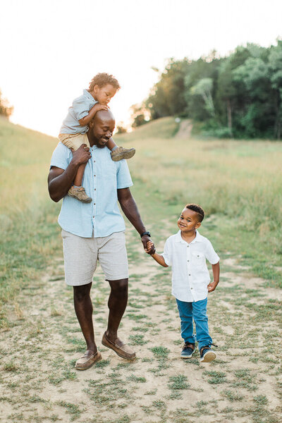 Portrait of black father and sons walking down a hill taken by Nashville Family Photographer