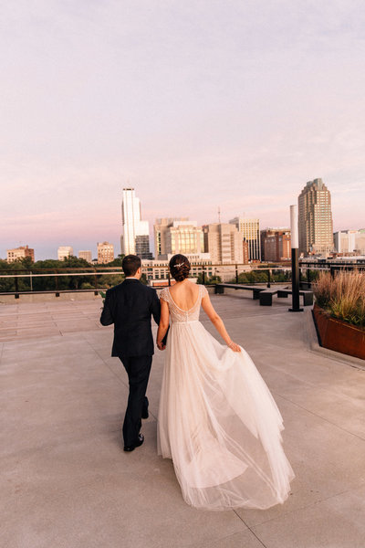 bride looks over downtown raleigh at the Dillon  rooftop