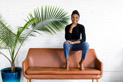 black woman with plants and couch