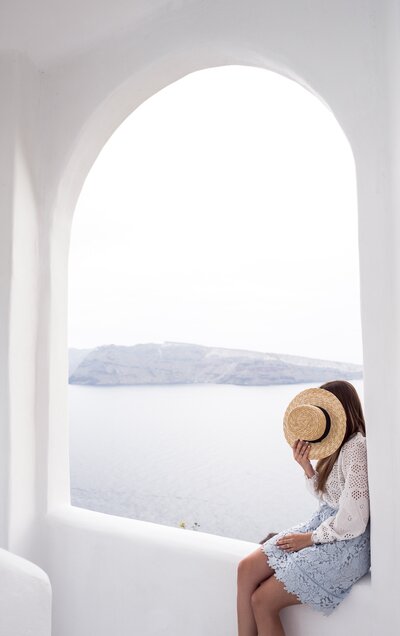 Santorini architecture, girl sitting in arched window