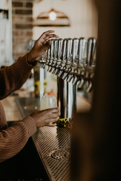 Girl pouring on tap cider at The Cider House in Vancouver BC