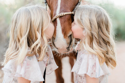 two girls kissing their horse