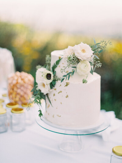 AZ Wedding Photos two tier wedding cake with gold details and white and green flowers