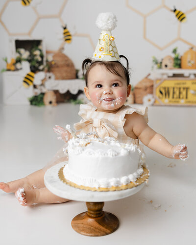 This birthday girl can’t stop smiling as she enjoys her cake at her bee-themed first birthday session. Captured with love and joy by Yucaipa cake smash photographer, Kaitlyn Dawn Photography.
