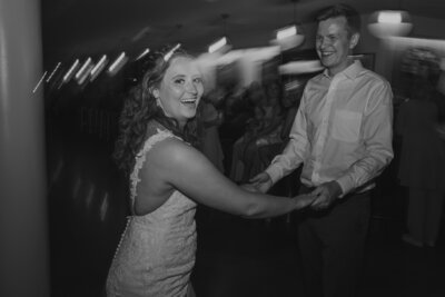 bride and groom dancing at wedding reception at boulevard brewery in kansas city missouri. Flash photography at reception during dancing to capture candid moments