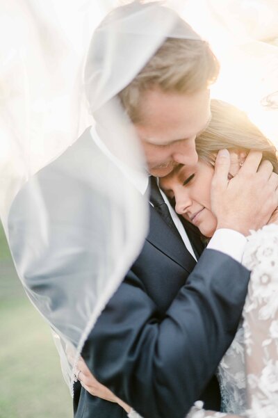 couple embracing with veil over them