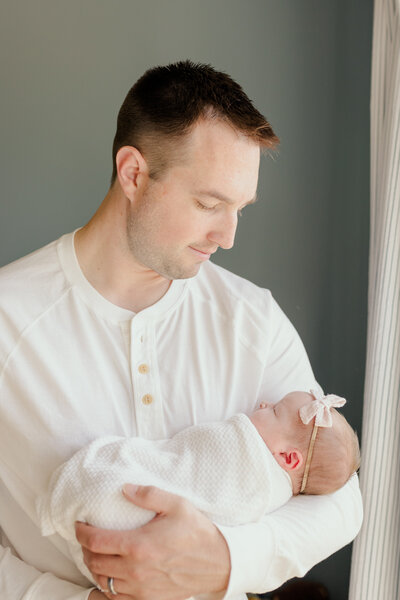 father holding newborn baby girl