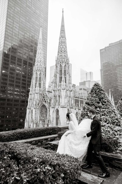 Black and White photography of a couple walking towards St. Patrick's Cathedral on their wedding day by CT wedding photographer Simply K Studios.