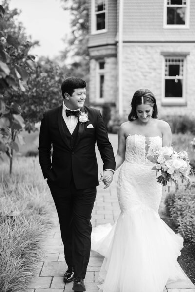 Bride and groom in black and white photo walk path outside of Willows at Ashcombe