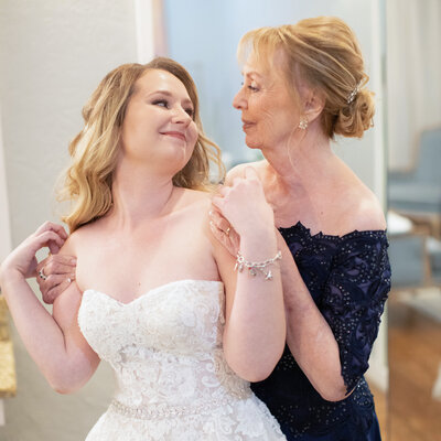 mother of the bride in navy dress gives hug in bridal suite at Milestone Boerne Texas by Firefly Photogarphy