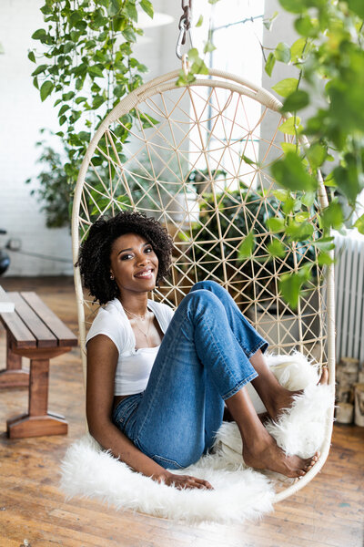 black woman with plants and swinging chair