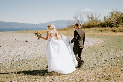 bride and groom walk the beach in tahoe