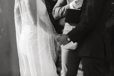 Bride and groom holding hands during intimate wedding ceremony