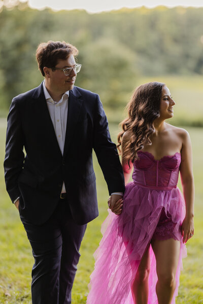 A couple walking holding hands at their engagement session  at Longwood Gardens at golden hour