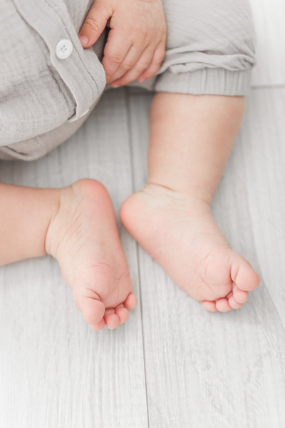 A photo of baby toes on grey wood flooring by washington dc baby photographer