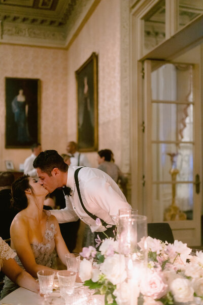 A couple kiss at a wedding reception at Rosecliff Mansion in Newport