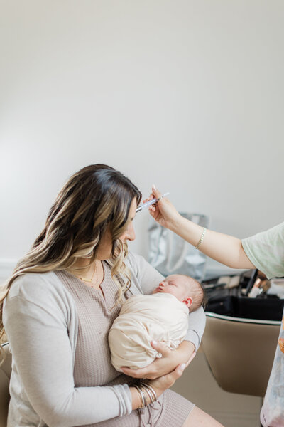 mom being pampered with professional hair and makeup before her south jersey newborn photography session