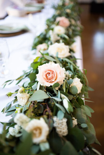 Floral garland on head table with roses, eucalyptus and more