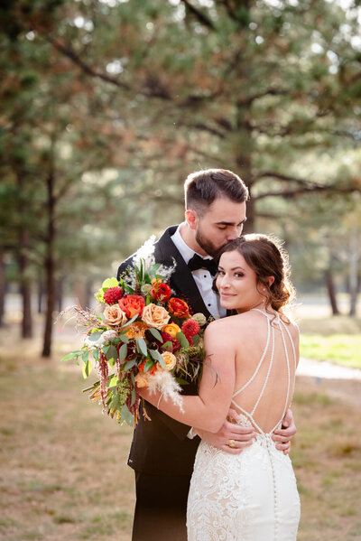 Newly married bride and groom pose outside at Spruce Mountain Ranch