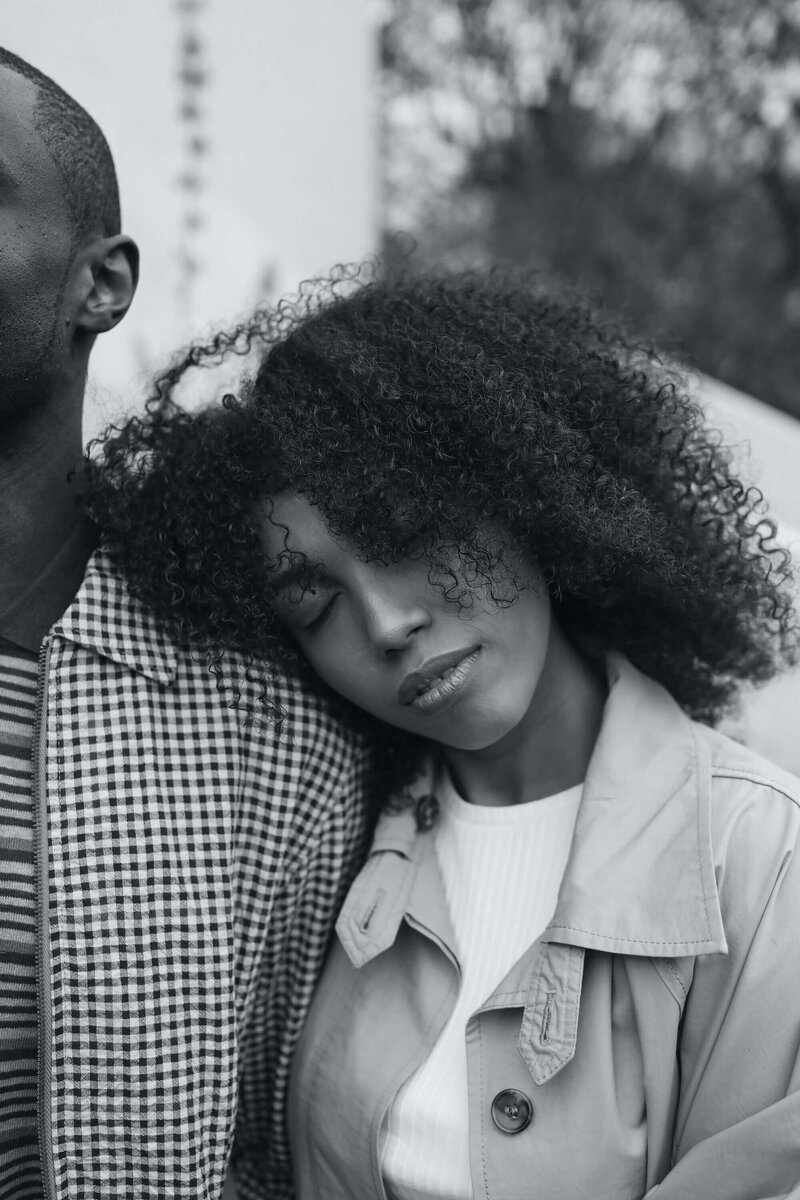 black woman leaning her head against the shoulder of her man