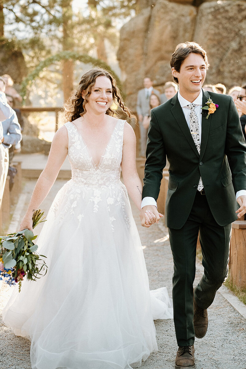bride and groom walk down the aisle after wedding ceremony in colorado at Deer Creek Valley Ranch