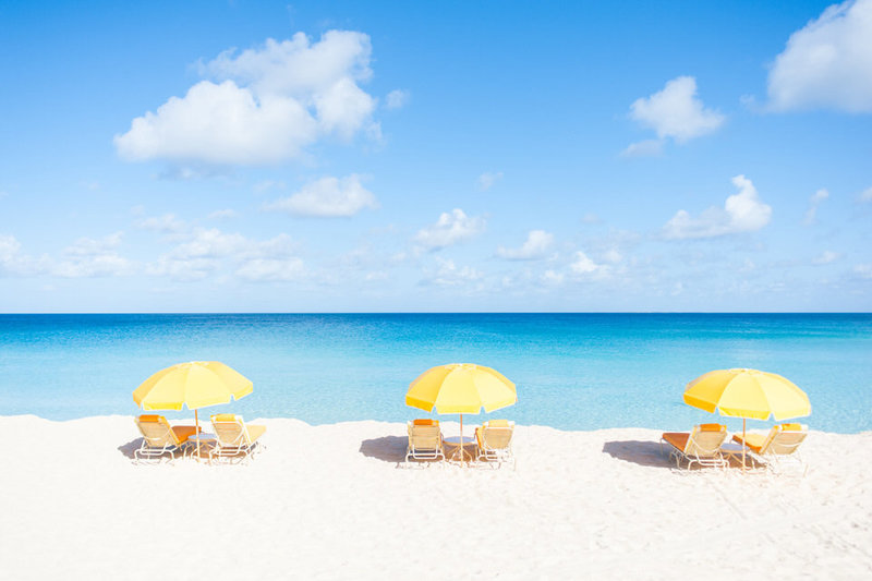 three yellow beach umbrellas at malliouhana's mead's bay in anguilla