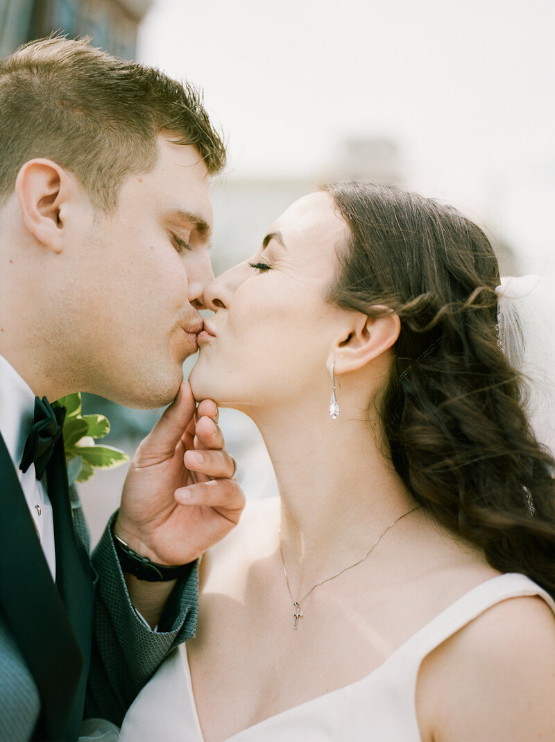 A couple kisses on their wedding day, hosted at the Durant in Flint, Michigan. Makeup