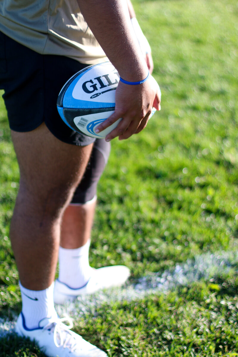 USAFA Men's rugby player holding rugby ball - Zoomie Rugby