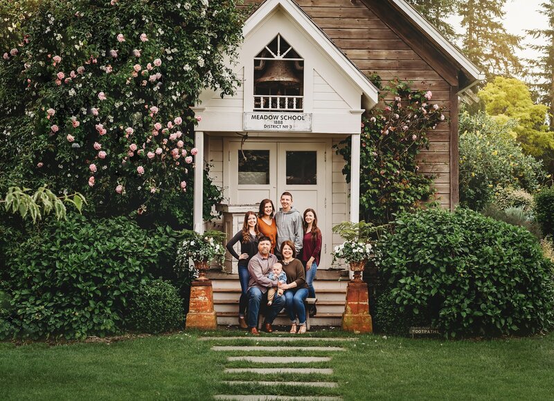Family sits on the front steps of their home for family portrait