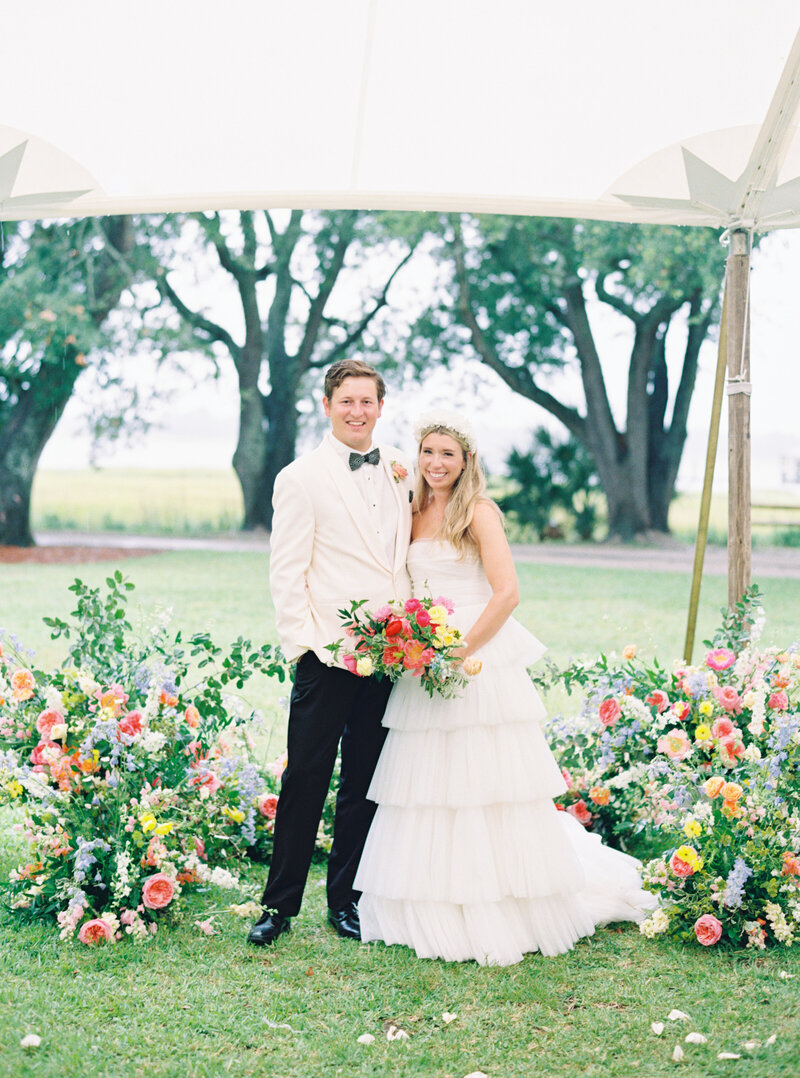Bride and groom portraits on film. Charleston wedding photographer. Lowndes Grove wedding with bright spring flowers.