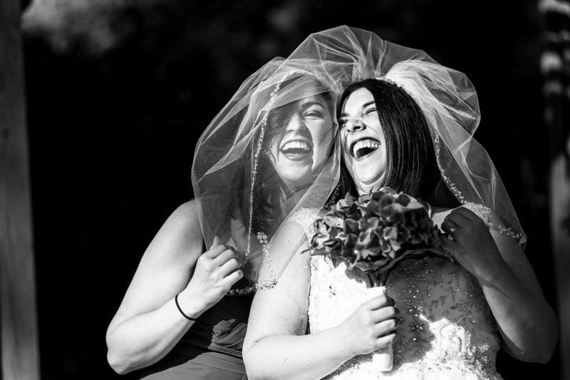 Bride laughs with her sister at St. Mary's Catholic Church wedding