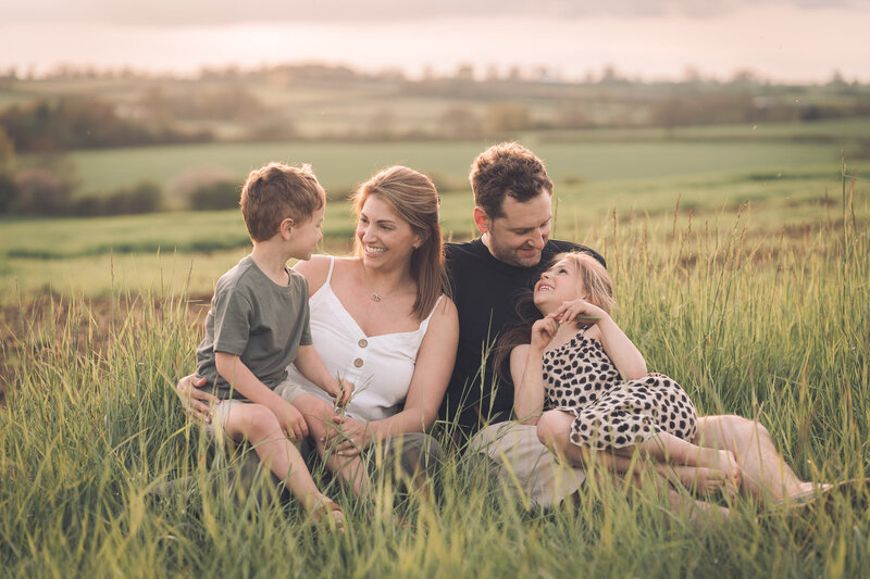 family sitting in grass field