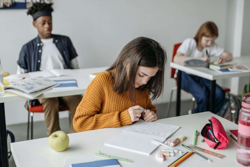 A student working at the desk in their classroom
