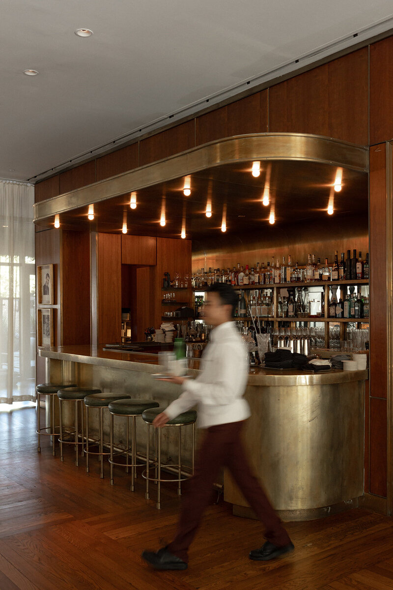 Bar area at the Dewberry hotel in CHarleston with motion blurr waiter captuted by Charleston Wedding Photographers
