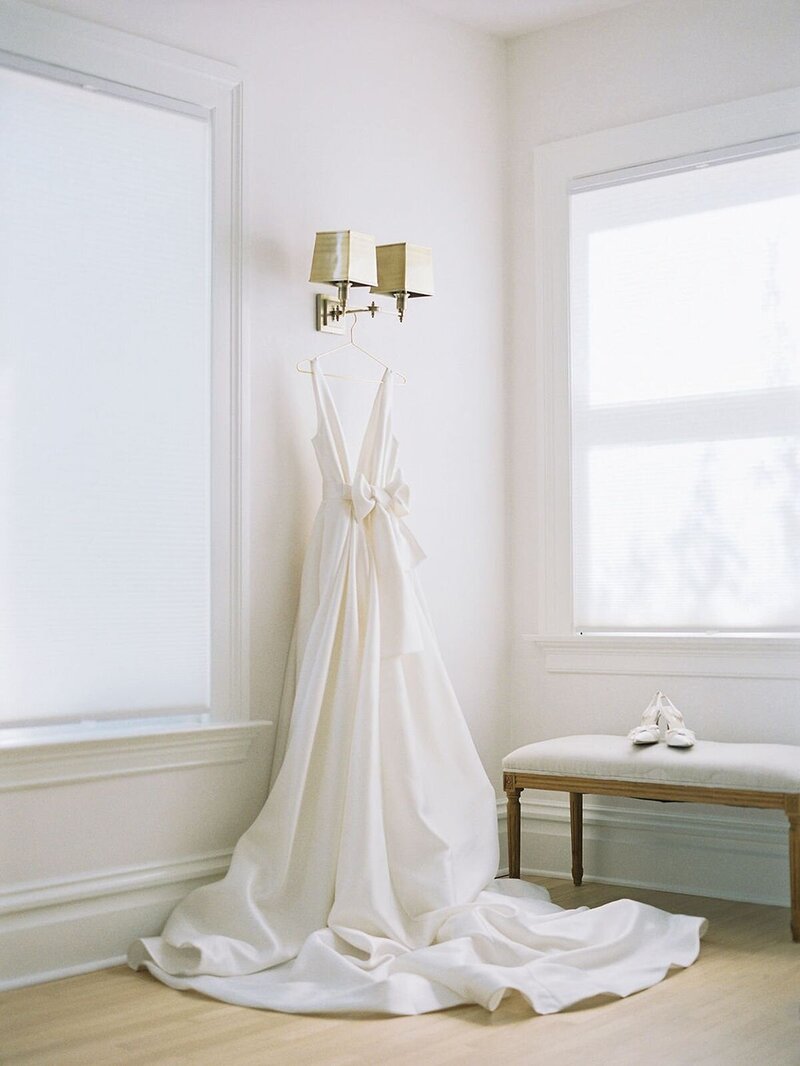 white wedding gown hanging by wall