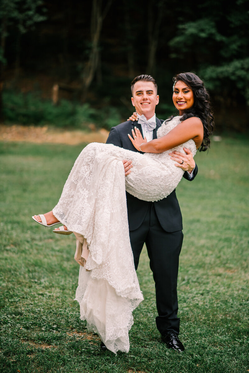 Groom lifts bride for photo in Saylorsburg PA.