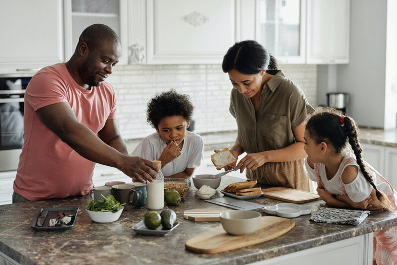 A family cooking together, a picture of teamwork and bonding over the preparation of a meal, highlighting shared responsibilities.