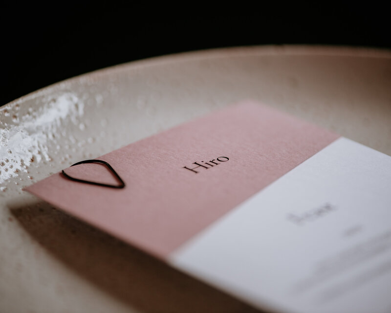Pink and white wedding place card and menu with black teardrop clip on textured paper
