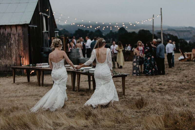 Two woman walking to their wedding reception among friends and family