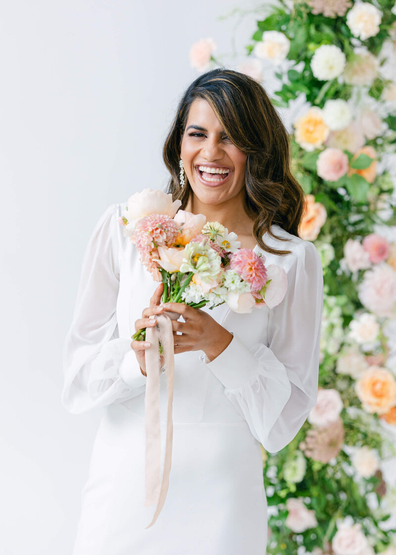 bride holding bright colored bridal bouquet and smiling