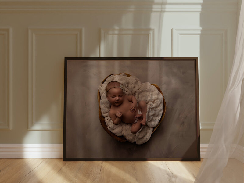 A squishy newborn sleeping peacefully in what is called the bum up pose. You can see his tiny newborn details perfectly, including the fat rolls on his back.  The lighting highlights his features perfectly, as the red backdrop and blanket compliment his gorgeous skin tone.