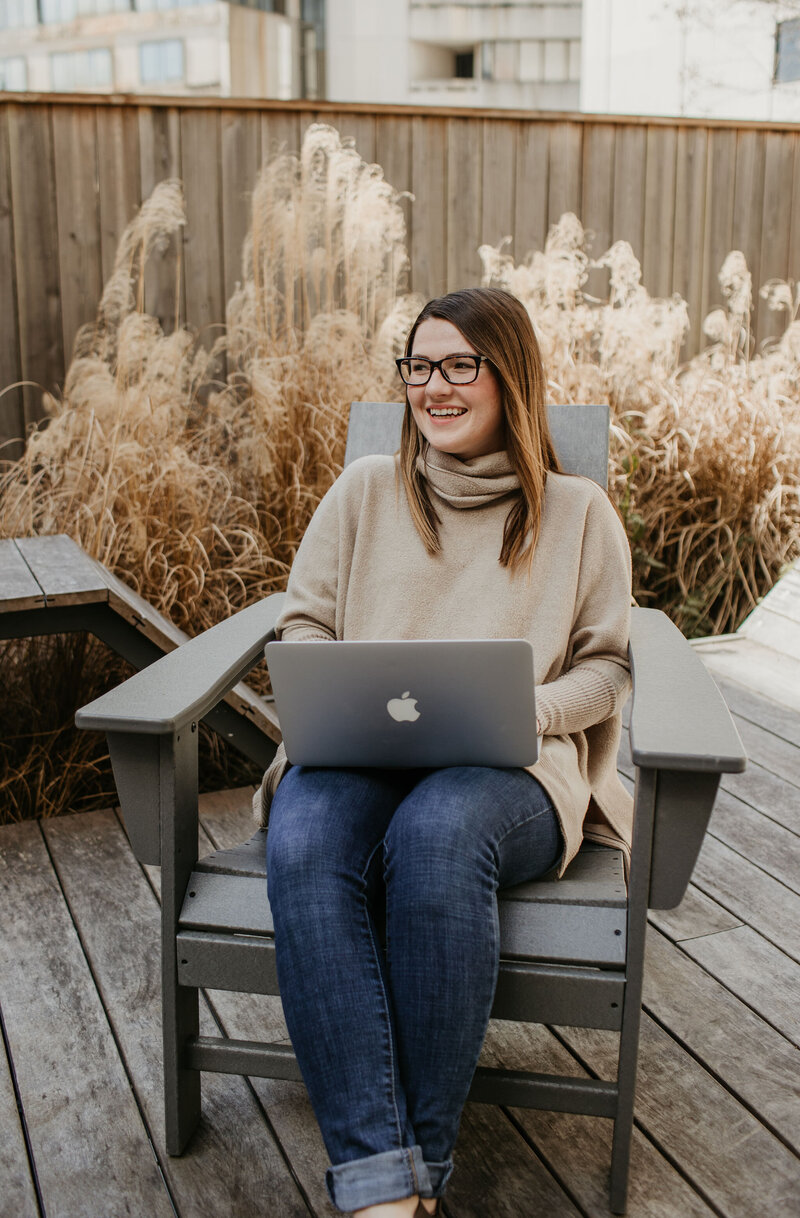 Woman on her laptop outside and smiling