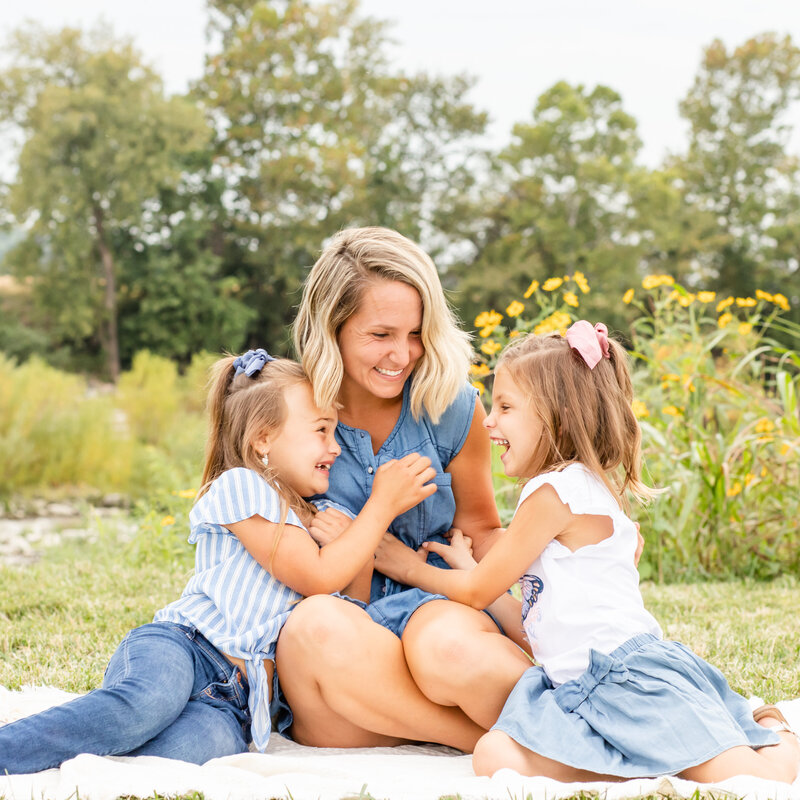 Mother and daughters tickling and laughing at outdoor family session