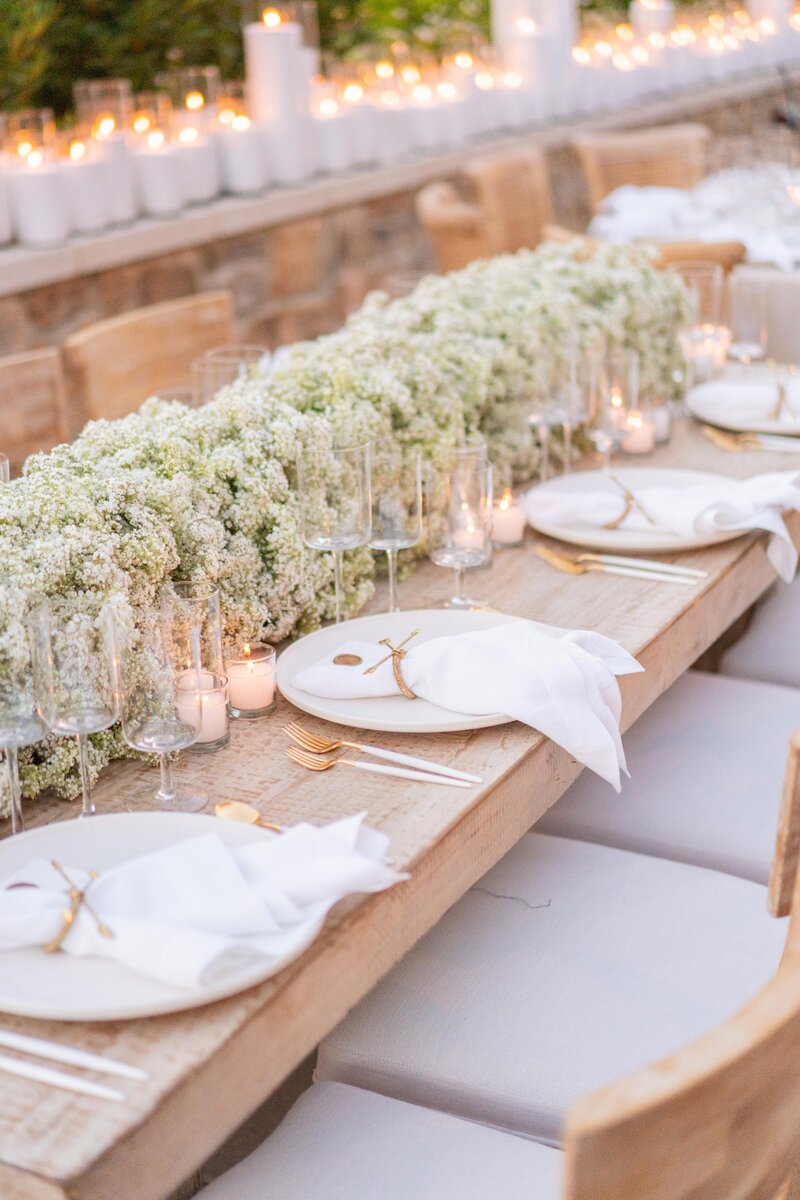 Close up of a long wedding table decorated with baby's breath flowers